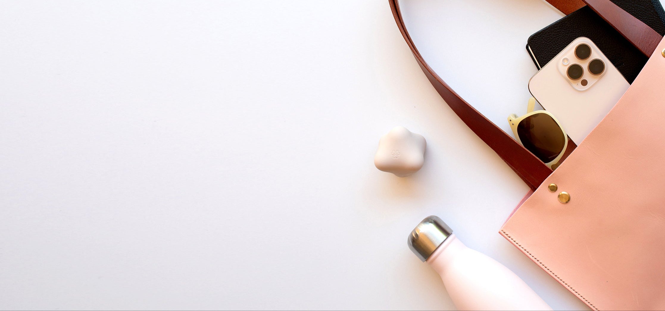 AYA STAR with pink handbag with phone, sunglasses, and water bottle on a white background
